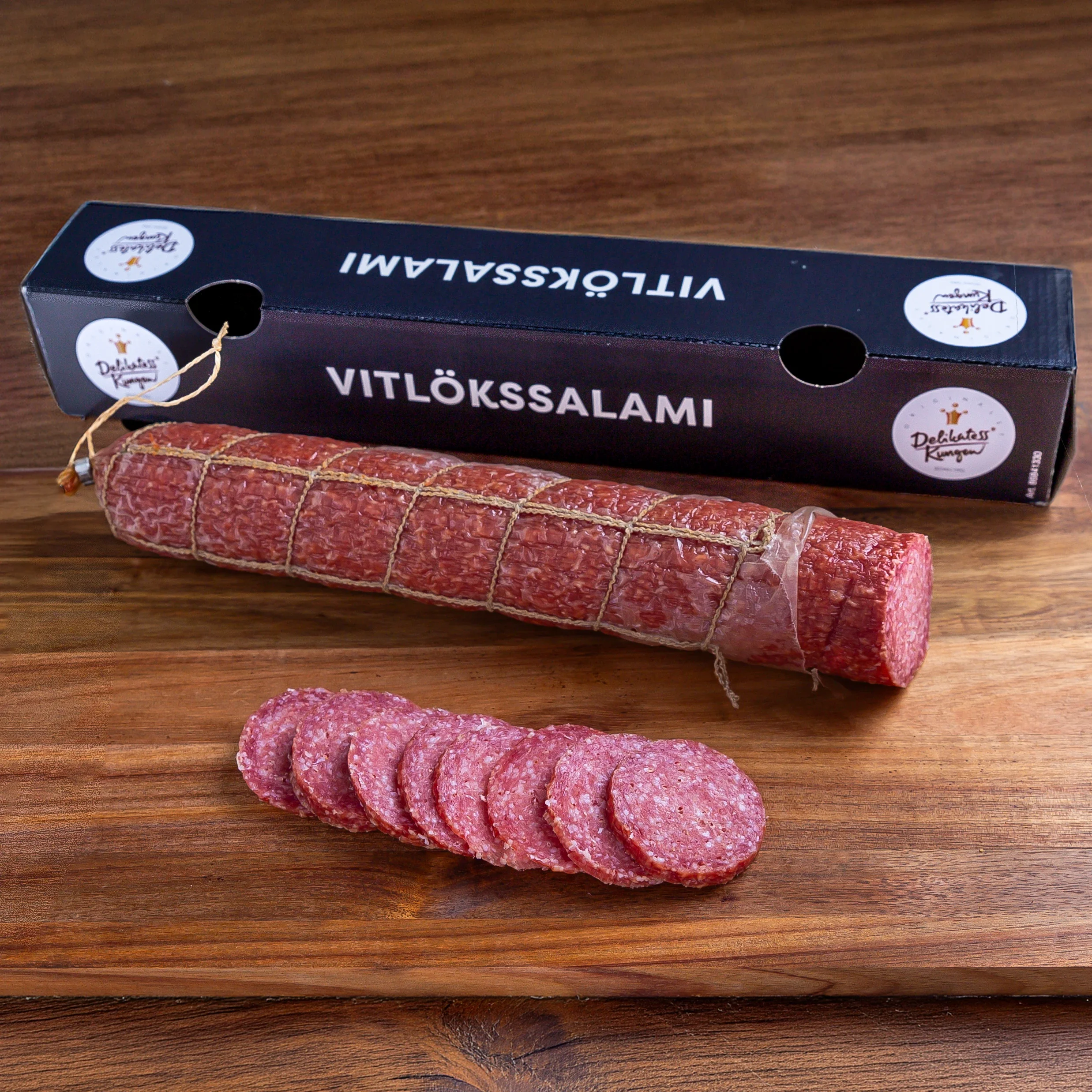 Vitlökssalami från delikatesskungen på skärbräda och låda jämte